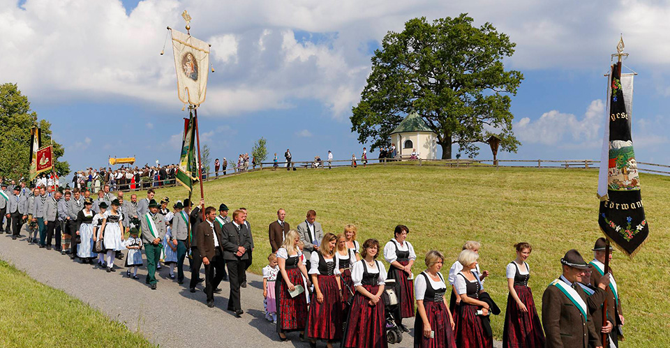 Fronleichnamsprozession mit Kirchenbannern und Fronleichnamshimmel