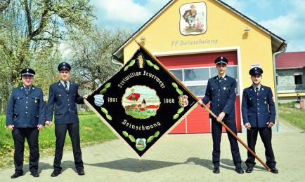 Die Vertreter der Feuerwehr Deinschwang präsentieren die restaurierte Fahne