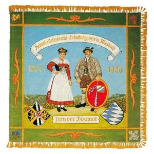 Precious old homeland club flag with couple in typical Miesbach costume in front of mountain silhouette